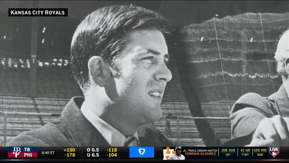A vintage black-and-white photograph from the Kansas City Royals featuring a man in profile view, displayed as part of a sports broadcast showing betting odds for a TB vs PHI game.