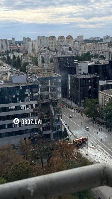 A Kyiv streetscape shows the aftermath of a Russian missile attack, with a heavily damaged multi-story building and debris scattered across the road, while emergency responders work at the scene. The watermark "OBOZ.UA" is visible on the image, documenting the destruction that left 31 injured and five killed, including one child.