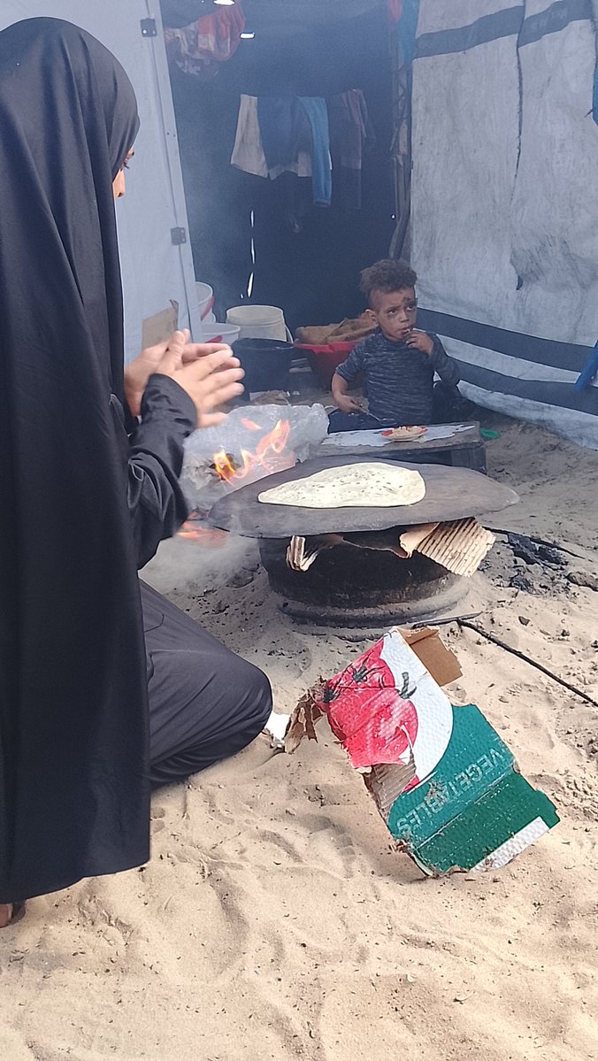 UmKhalilGaza's tweet photo. A mother in Gaza. No home. No oven.
I baked bread on the sand for my hungry son.
We are still here. 💔🇵🇸
#Gaza #KhanYounis https://t.co/3pC2GWP22c