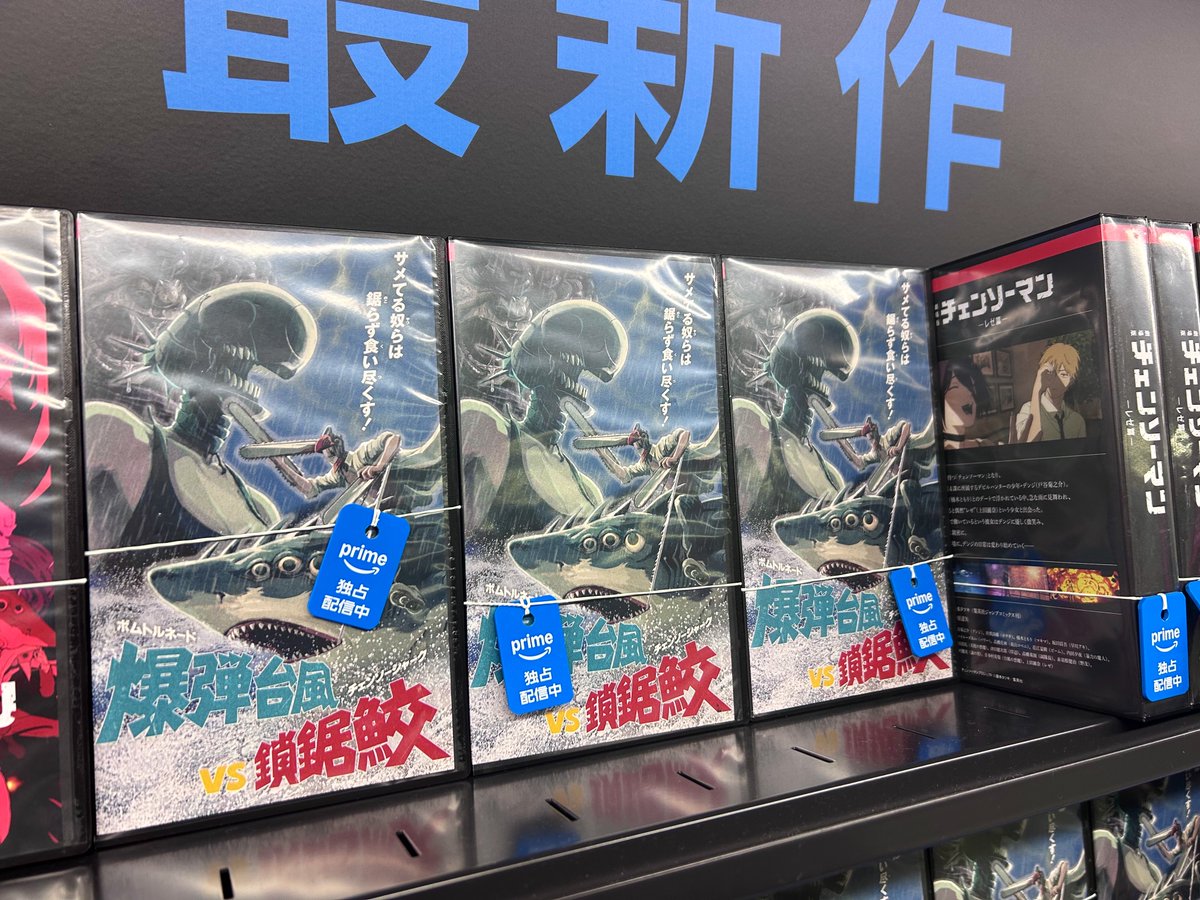 cccutthecrap's tweet photo. 新宿駅のチェンソーマンの広告神だった。レンタルビデオショップに見立てて実在のサメ映画とパロディ並べて、ビデオは実際に手に取れる🦈📼 https://t.co/OoNCAiW4AJ