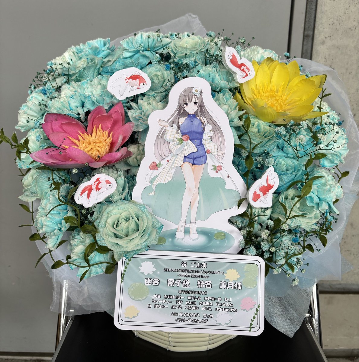ebisan_daisuki's tweet photo. シャニマスMSPにご出演される幽谷 霧子さん・結名 美月さんへ、有志一同より楽屋花を贈らせていただきました

イラスト：伊佐らっとる( @isarattrap )様

マイコレイラストから、ランウェイを水面に浮かぶ花や金魚といっしょに演出する姿をお花にしました
#シャニマスソロライブMSP https://t.co/aRZtP8oGey