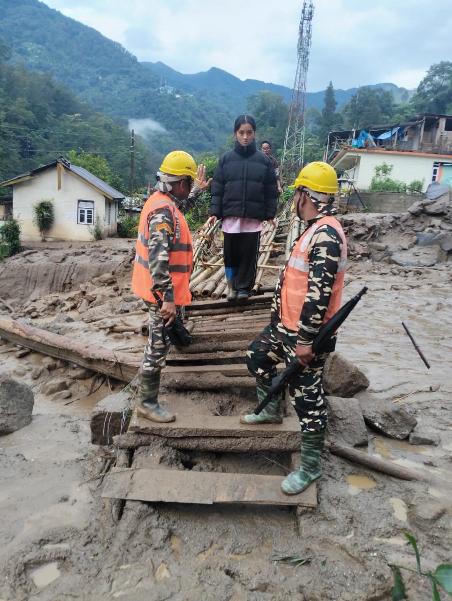 SSB_INDIA's tweet photo. दिनांक 24.09.2026 को भारी वर्षा के कारण #सिक्किम के रिम्बी गाँव में भूस्खलन हुआ, जिससे सड़क मार्ग पूरी तरह क्षतिग्रस्त हो गया है।
#SSB की 72वीं वाहिनी की #RRT टीम राहत एवं बचाव कार्य में जुटी ह���।
बांस का पुल बनाना हो या रेस्क्यू ऑपरेशन—हर प्रभावित परिवार तक मदद पहुँचाने का संकल्प अडिग है, चाहे राह कितनी भी मुश्किल हो।
सेवा • सुरक्षा • बंधुत्व 🇮🇳
#SSBIndia #Sikkim #Rimbi #DisasterResponse #LandslideRelief 
#NationFirst 
@PIBHomeAffairs 
@ANI @PTI_News 
@mygovindia
