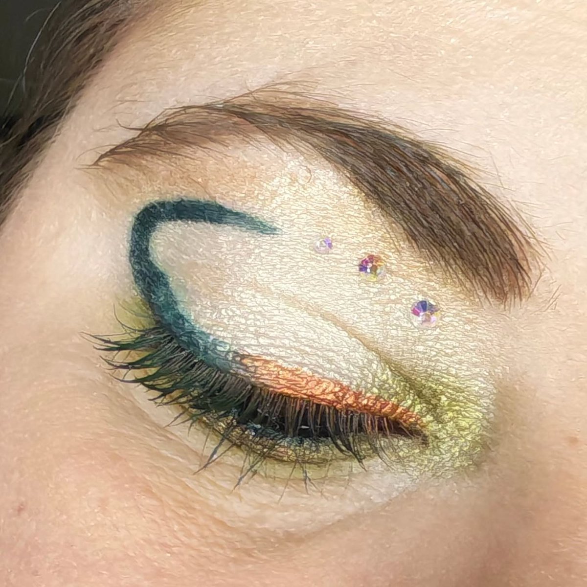 IanKozatek's tweet photo. Éclat sauvage : reflets dorés, vert intense et touches scintillantes pour capter la lumière. Un maquillage créatif et audacieux, pensé pour exprimer sa personnalité sans limites. https://t.co/ViNWtU41Lr