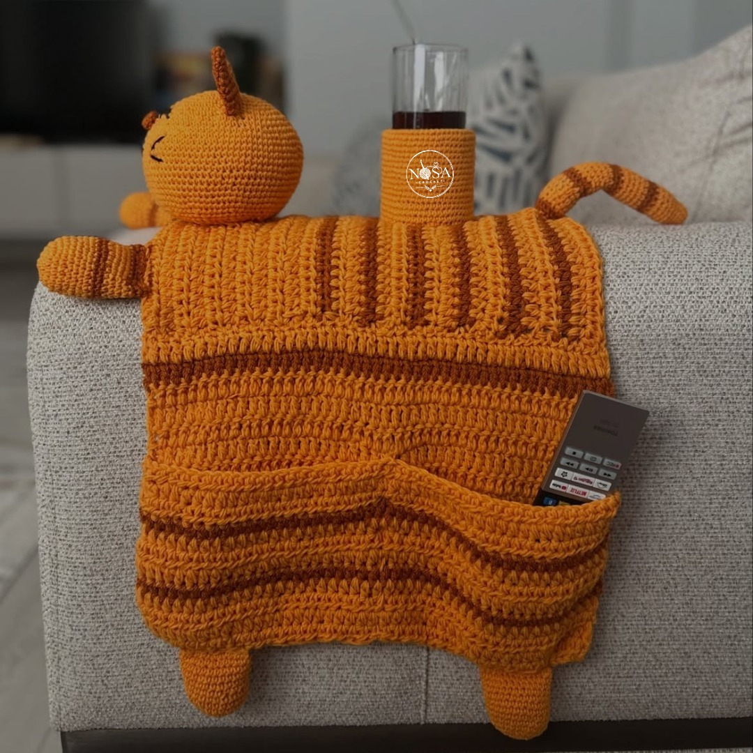 GrahamEiseck's tweet photo. Elevate your living space with this charming handmade cat armrest organizer and cup holder. Crafted from durable mercerized cotton, it features textured stitching, 3D cat details, side pockets, and a cozy orange tabby design. https://t.co/RoTgdEta7i