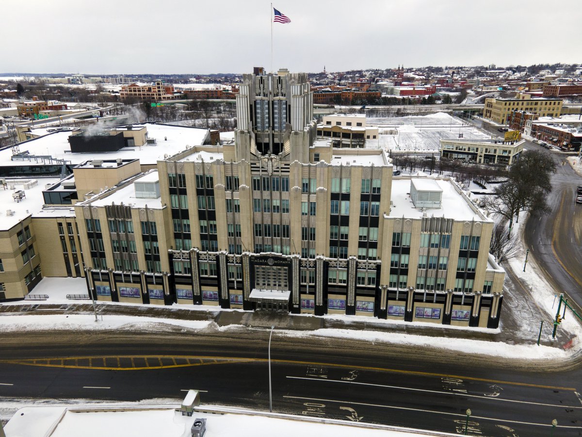 gietzschean's tweet photo. Art Deco actually made a power company building look exactly like a power company. 

The Niagara Mohawk Building in Syracuse was completed in 1932 as the headquarters of Niagara Hudson Power Corporation.

At night, concealed lights within the façade, illuminated glass panels, floodlighting on the central 'Spirit of Light' sculpture, reflective aluminum, polished glass and stainless steel turned the building into a glowing advertisement for the power of electricity in the age of machine. 

This also represented the optimism and beauty that could be incorporated into modernist structures.