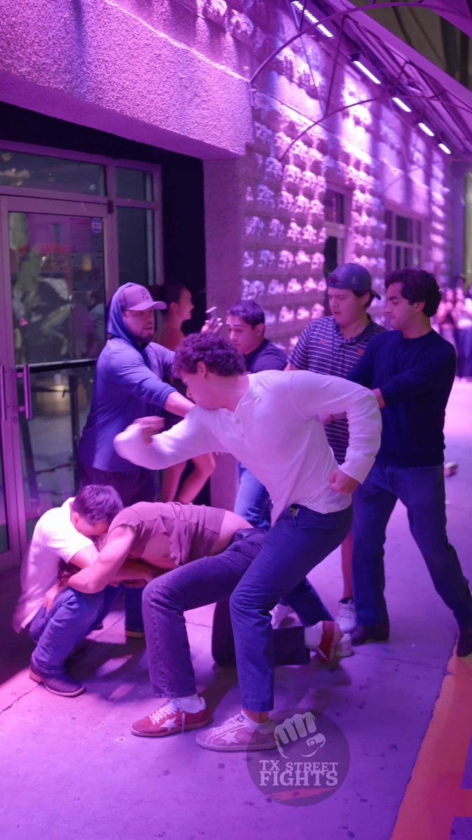 A chaotic nighttime brawl erupts on a purple-lit sidewalk outside a Downtown Austin venue, with several men actively shoving and tackling one another. The watermark "TX Street Fights" appears in the corner, aligning with the post's hashtag #6thstreet and September 24, 2026 location tag capturing the street violence.