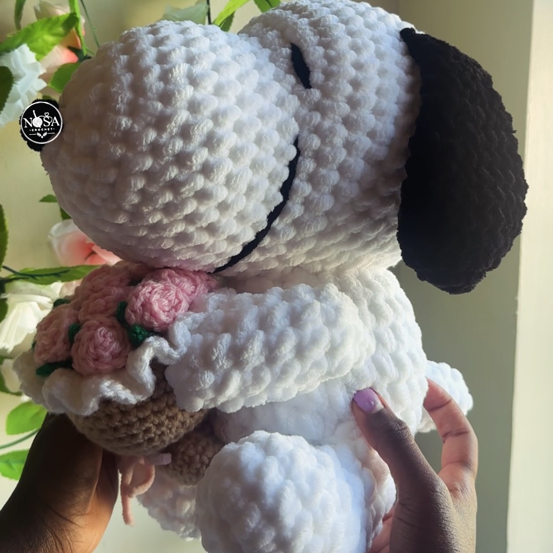 GrahamEiseck's tweet photo. Handcrafted with ultra-soft plush yarn, this crochet Snoopy holding pink roses is made to warm hearts. Custom orders are available, from baby booties and sweaters to home décor. Message us to reserve yours. https://t.co/yoveqcxm7T