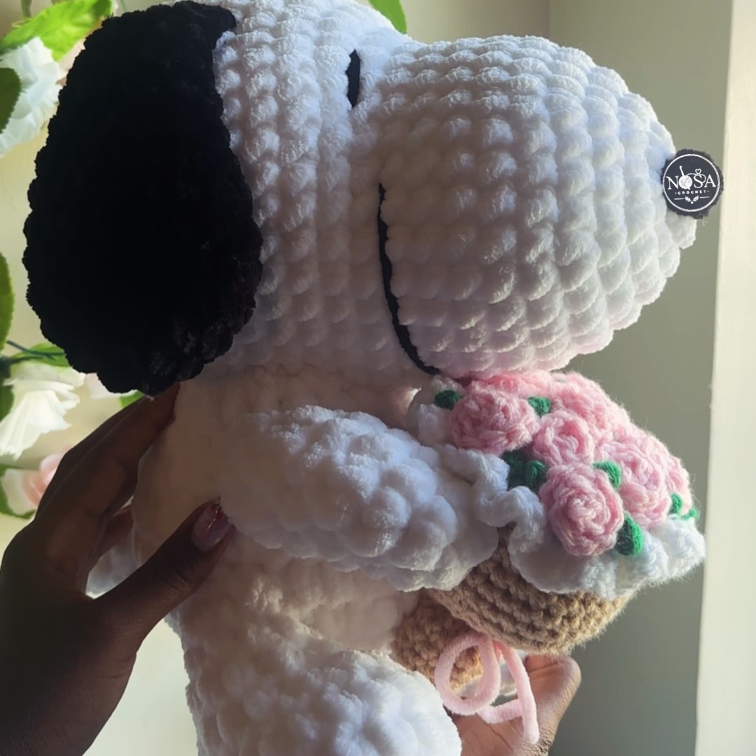 GrahamEiseck's tweet photo. Handcrafted with ultra-soft plush yarn, this crochet Snoopy holding pink roses is made to warm hearts. Custom orders are available, from baby booties and sweaters to home décor. Message us to reserve yours. https://t.co/yoveqcxm7T