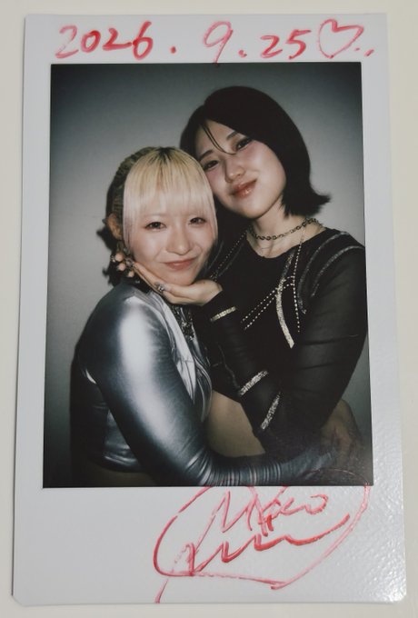 A Polaroid photo dated '2026.9.25' featuring two young women posing closely together, with a pink signature at the bottom.