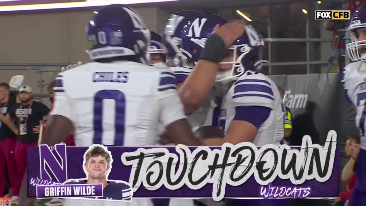 Northwestern football players celebrate a touchdown by Griffin Wilde (#0) during a FOX CFB broadcast, with on-screen graphics reading "TOUCHDOWN WILDCATS" and "GRIFFIN WILDE." The image relates to the post about Indiana as it appears to show Northwestern scoring against the Hoosiers.
