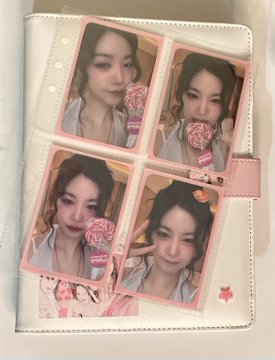 A photo album displays four pink-bordered selfies of a young woman posing playfully with lollipops, styled to mimic the iconic "Lollipop" MV photoshoots. The Portuguese caption translates to "I'm the first in my family tree to have the Soojin puppy lollipop page from Pixy," referencing a fan-made photobook theme based on Soojin from the K-pop group (G)I-DLE, whose concept matches the lollipop aesthetic shown in the selfies.