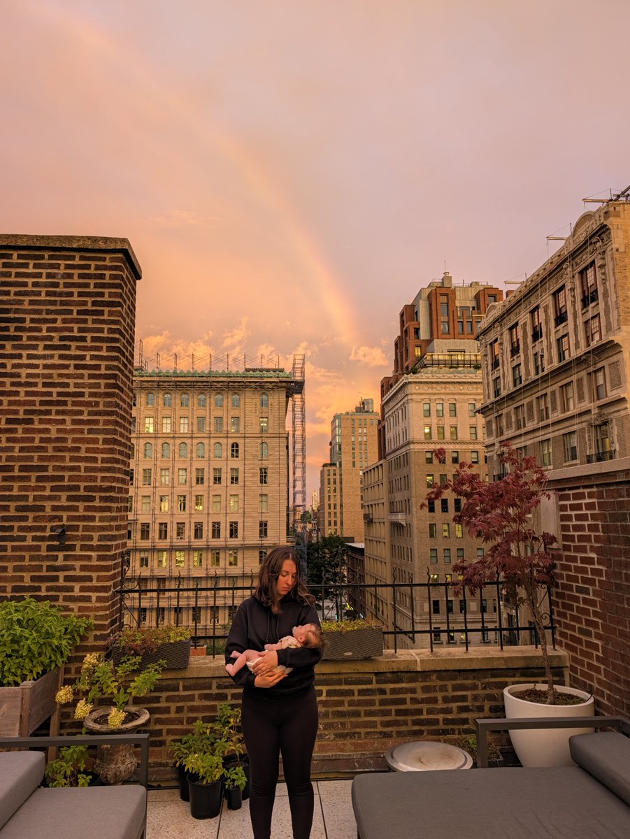 cameronmattis's tweet photo. my beautiful wife holding my perfect infant daughter on our terrace at sunset while a rainbow blooms in the background. what a life. blessed beyond words. https://t.co/r37wIbZ8WH