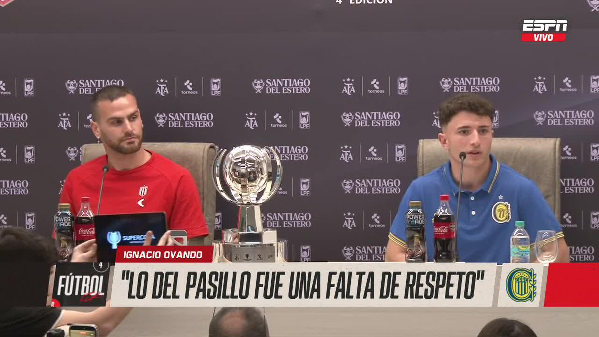 Two Argentine football players sit at a press conference in Santiago del Estero, with the ESPN broadcast identifying them as Estudiantes' Pérez and Rosario Central's Ignacio Ovando, alongside a Super Cup trophy and a chyron reading "LO DEL PASILLO FUE UNA FALTA DE RESPETO" ("The hallway thing was a lack of respect"), capturing the tense exchange over the controversial corridor incident between the rival clubs.