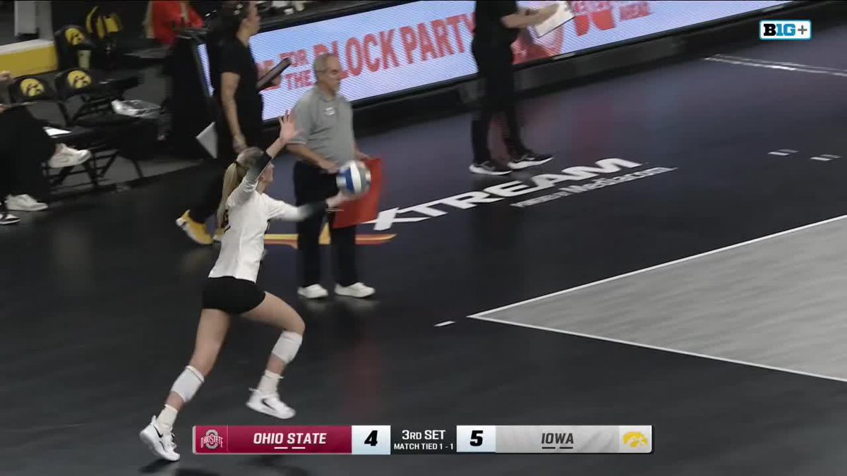 A volleyball match between Ohio State and Iowa, with Ohio State player serving during the 3rd set while the scoreboard shows Ohio State 4, Iowa 5.