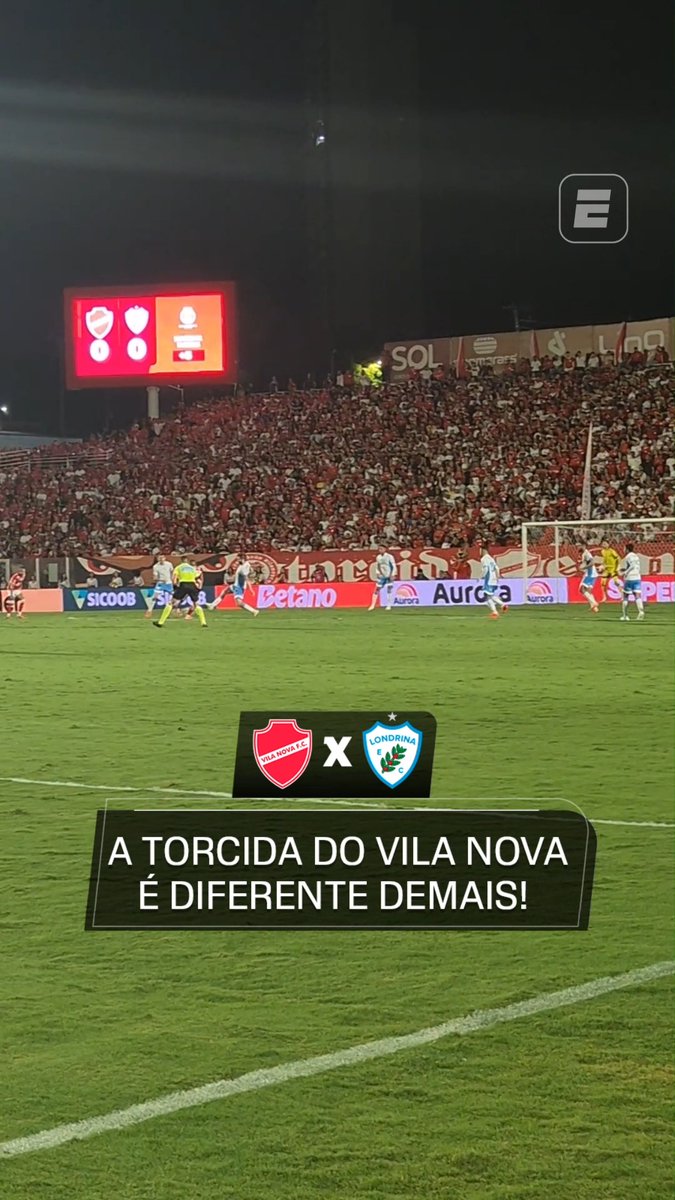A nighttime football match scene shows Vila Nova facing Londrina, with team logos displayed on the field and the caption "A TORCIDA DO VILA NOVA É DIFERENTE DEMAIS!" overlaid on the image. The stands are packed with fans wearing red, while advertising boards for Betano, Aurora, Sicoob, and others line the pitch alongside the ESPN logo.