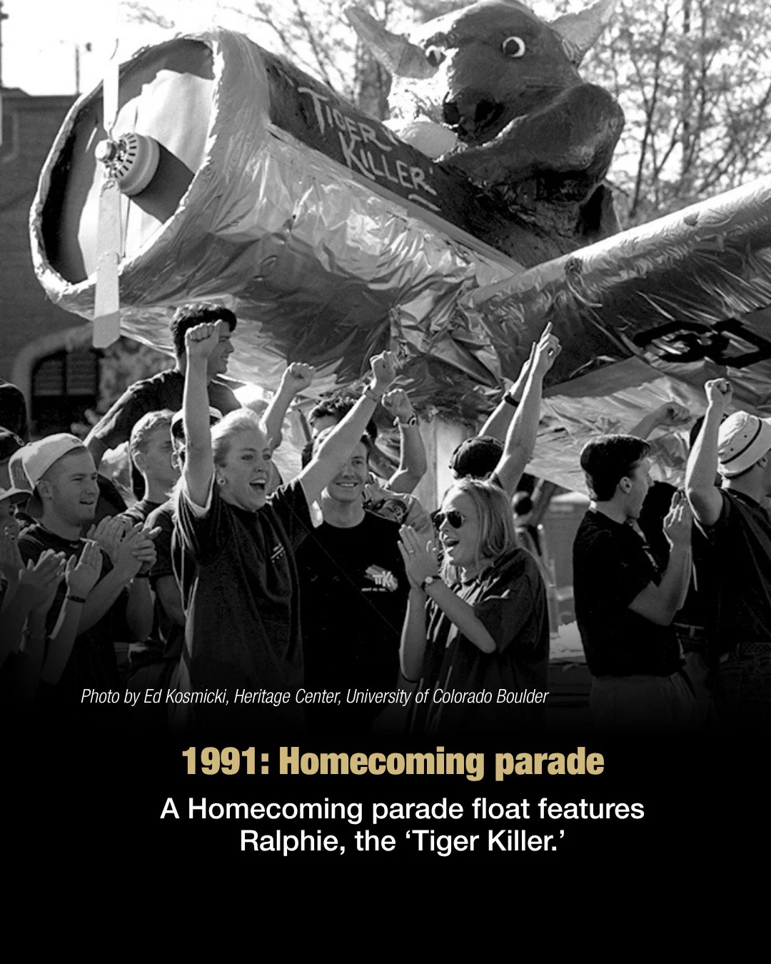 A group of students cheer and laugh under an airplane-styled parade float. Text reads: 1991. Homecoming parade. A Homecoming parade float features Ralphie, the "Tiger Killer."