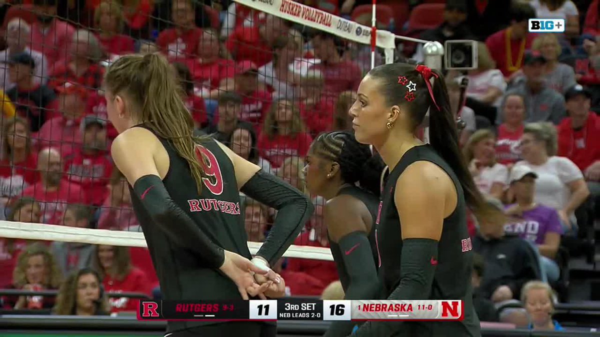 A volleyball match broadcast showing Rutgers players in black uniforms on the court, with the score ticker reading 'RUTGERS 9-1 11' and 'NEBRASKA 11-0 16' during the 3rd set.