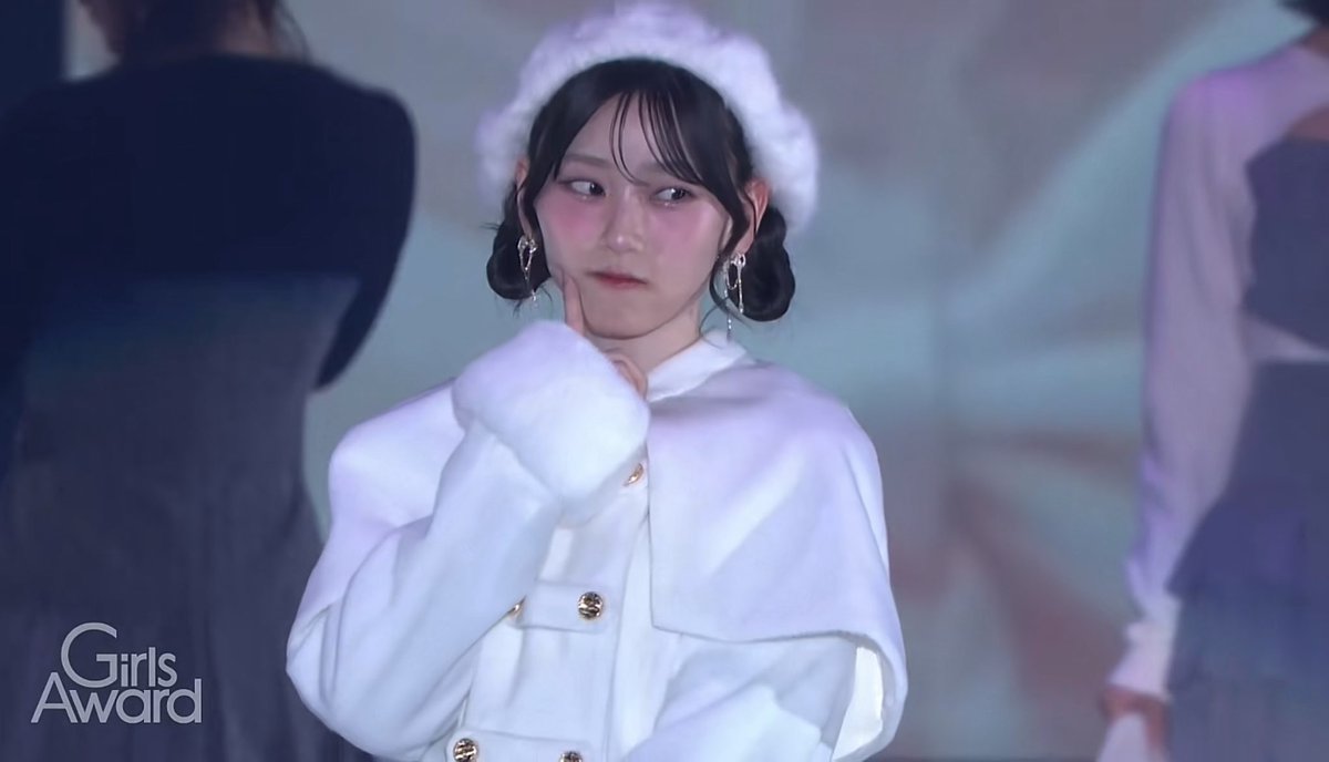 A young woman with braided hair and a white fuzzy beret wearing an elegant white outfit at the 'Girls Award' event.