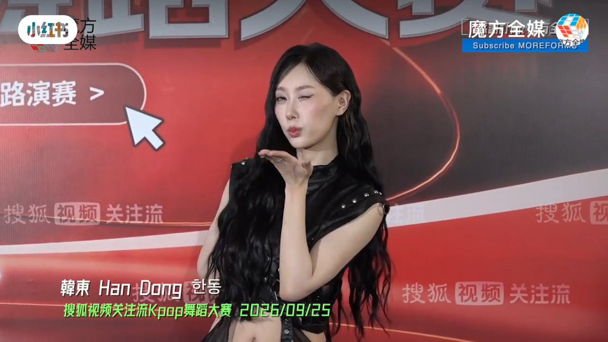 Screenshot of a video featuring a woman with long wavy black hair in a black leather outfit blowing a kiss, with text identifying '韩东 Han Dong' and '搜狐视频关注流Kpop舞蹈大赛 2026/09/25' along with a Little Red Book watermark.
