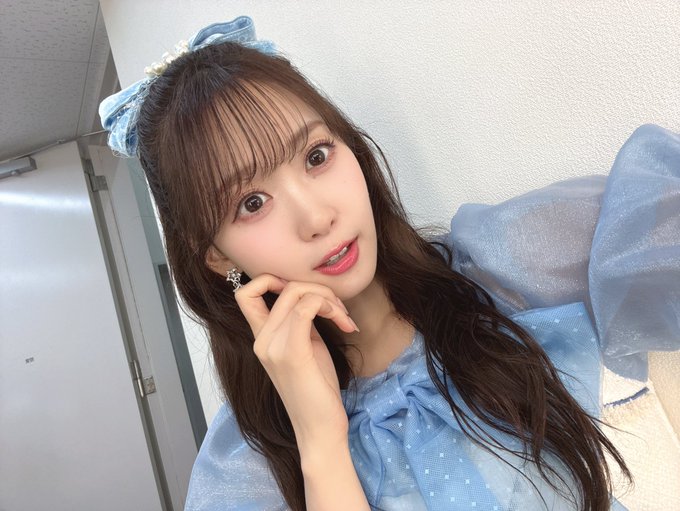Serico poses gracefully with a soft, ladylike expression, wearing a light blue polka-dot outfit with a matching sheer bow headband and a large decorative bow on her sleeve, reflecting the elegant charm referenced in the post about her Lily event appearance.