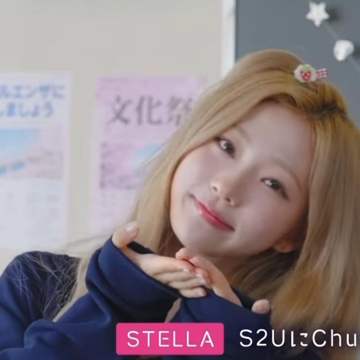 A young woman with blonde hair and a strawberry hair clip smiles at the camera, with the text 'STELLA S2UにChu' displayed at the bottom.