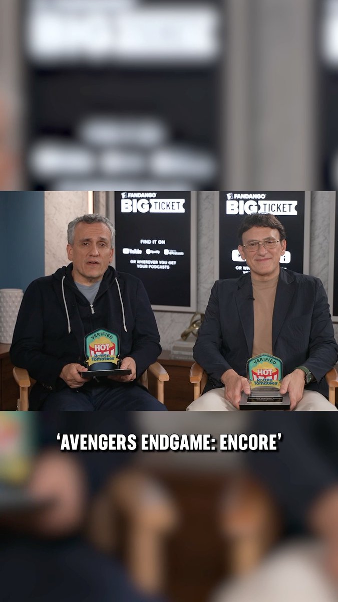 Two men sit holding Rotten Tomatoes 'Verified Hot' trophies during a podcast interview, with text reading 'AVENGERS ENDGAME: ENCORE' and banners for 'FANDANGO BIG TICKET' behind them.