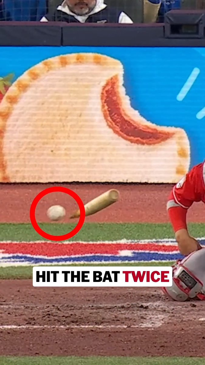 A baseball makes contact with a bat during what appears to be an unusual hit, with text overlay reading "HIT THE BAT TWICE." The image shows the ball in mid-air near the bat against a backdrop featuring a large cream-filled pastry advertisement, highlighting the remarkable and improbable moment referenced in the caption asking about the odds of such an occurrence.