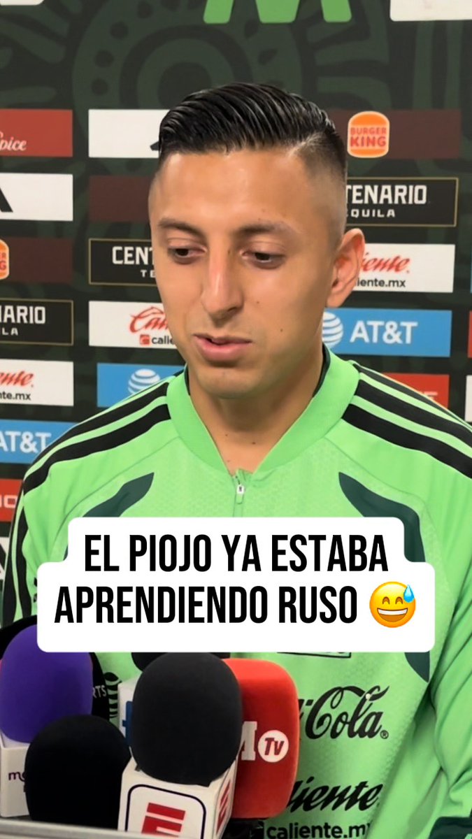 Roberto "El Piojo" Alvarado speaks at a press conference surrounded by sponsor logos (Burger King, AT&T, Centenario Tequila, Caliente.mx, Coca-Cola), with a text overlay reading "EL PIOJO YA ESTABA APRENDIENDO RUSO 😅," referencing his revelation that he had begun learning Russian due to rumored transfer interest from Spartak Moscow.