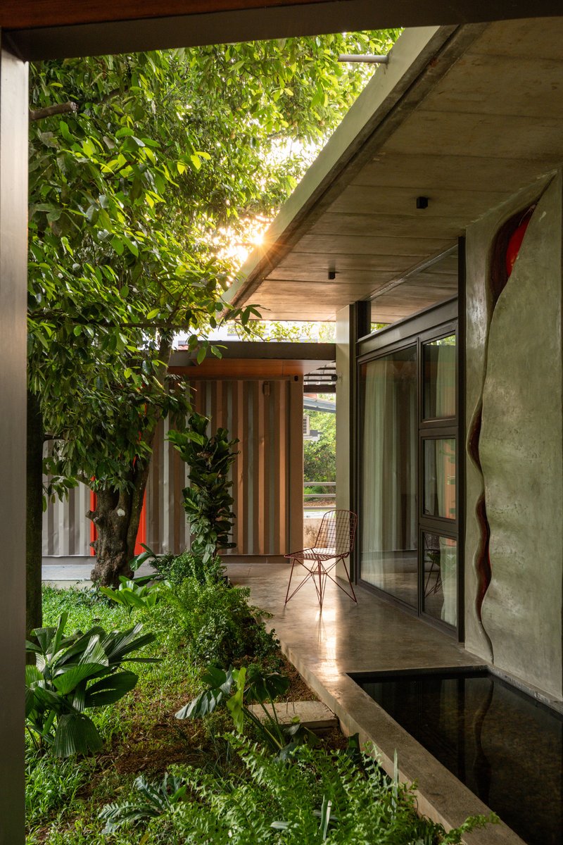 Architizer's tweet photo. Rather than clearing the site, The Mace Grove builds around its five existing nutmeg trees. A floating upper-level bedroom threads between two trunks, making the trees an integral part of the home’s architecture.

📍 Thrissur, India
Project by: Walls N Voids Atelier
Details: https://t.co/rHxCiFefhe