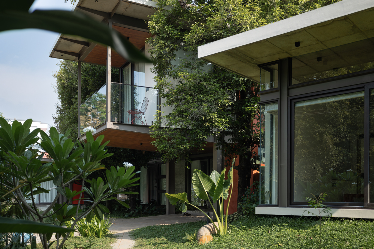 Architizer's tweet photo. Rather than clearing the site, The Mace Grove builds around its five existing nutmeg trees. A floating upper-level bedroom threads between two trunks, making the trees an integral part of the home’s architecture.

📍 Thrissur, India
Project by: Walls N Voids Atelier
Details: https://t.co/rHxCiFefhe