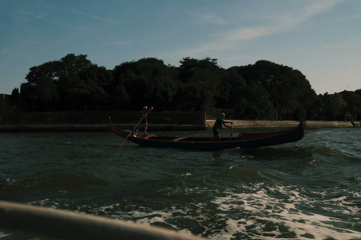 KarolLeemafa's tweet photo. People on the boat leave the safe canal and venture into rough seas with glass-like waves. At the end of Venice’s waterways, two solemn figures row in silence. Crossing the restless water begins by taking hold of the oars with your own strength. https://t.co/VuViJaoRcG