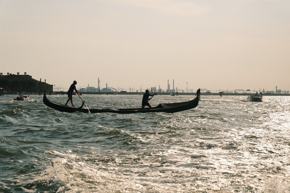 KarolLeemafa's tweet photo. People on the boat leave the safe canal and venture into rough seas with glass-like waves. At the end of Venice’s waterways, two solemn figures row in silence. Crossing the restless water begins by taking hold of the oars with your own strength. https://t.co/VuViJaoRcG