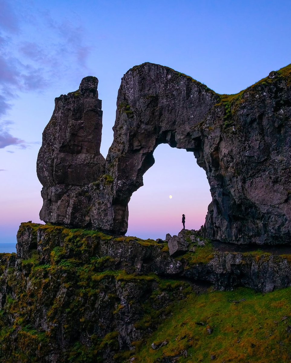Lemes95's tweet photo. A magical 11:30 PM summer evening unfolded in Iceland. A hike that was unplanned turned into a surprising moment as the moon started to rise. I promptly grabbed my camera and drone, successfully capturing it, with the stone arch in the foreground fra... https://t.co/UvQMl7YeMp
