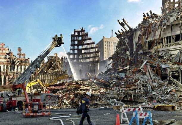 25YearsAgoLive's tweet photo. Firefighters spray a smoldering blaze at Ground Zero, which is still on fire 15 days after the September 11 attacks, making conditions dangerous for recovery workers. https://t.co/b32QdxleLt