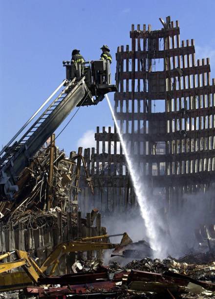 25YearsAgoLive's tweet photo. Firefighters spray a smoldering blaze at Ground Zero, which is still on fire 15 days after the September 11 attacks, making conditions dangerous for recovery workers. https://t.co/b32QdxleLt