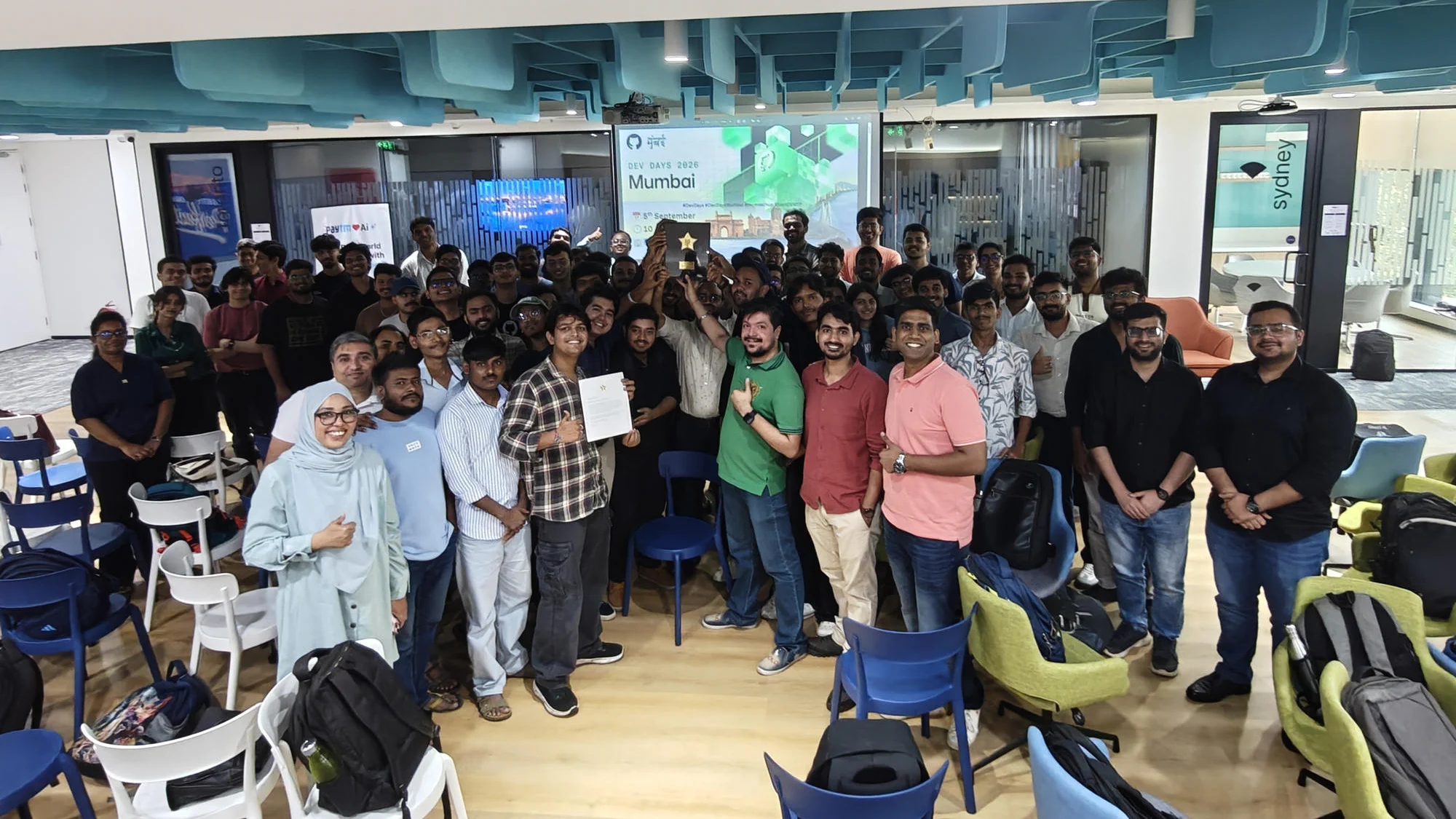 A group celebrates with an award in a meeting room.