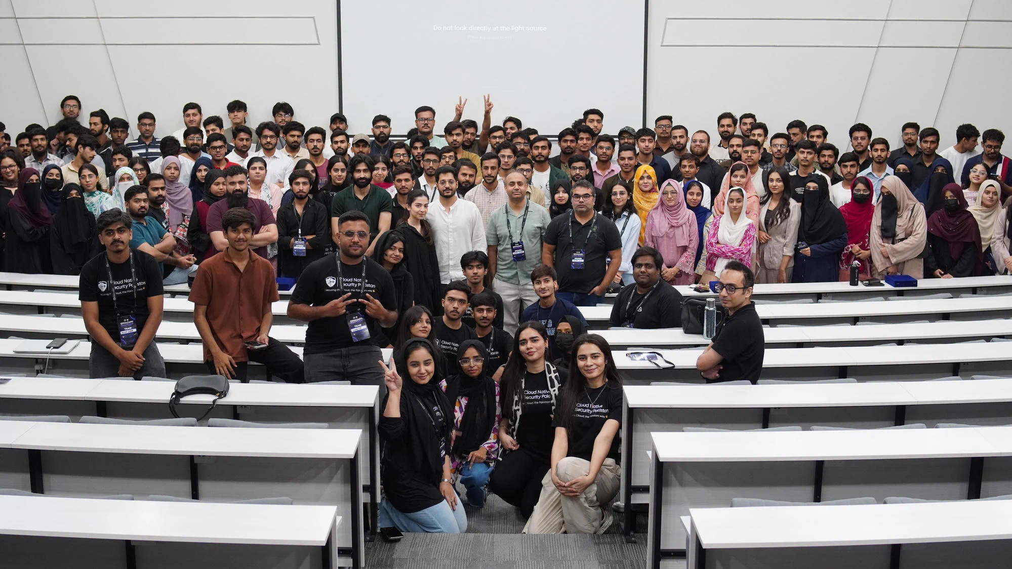 A large group gathers in a lecture hall.