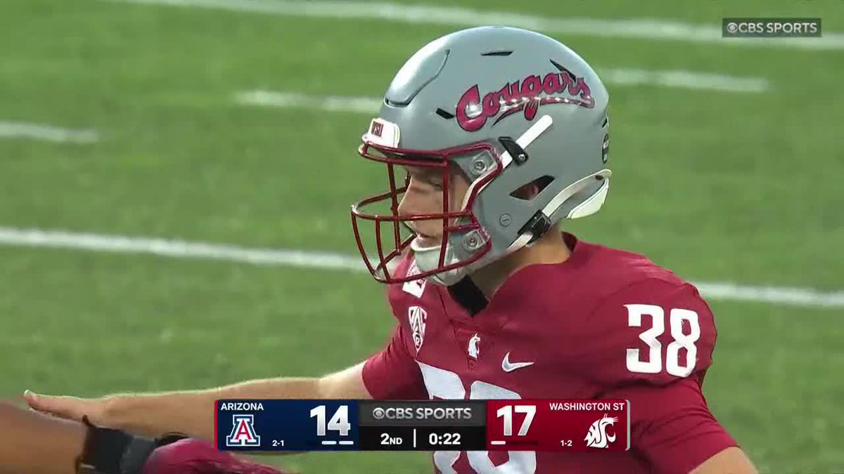 A football player wearing a Washington State Cougars helmet with the number 38 on his crimson jersey looks on during a game against Arizona. The CBS Sports scoreboard shows Washington State leading Arizona 17-14 with 22 seconds left in the 2nd quarter, matching the moment when the Cougars took the lead before halftime.