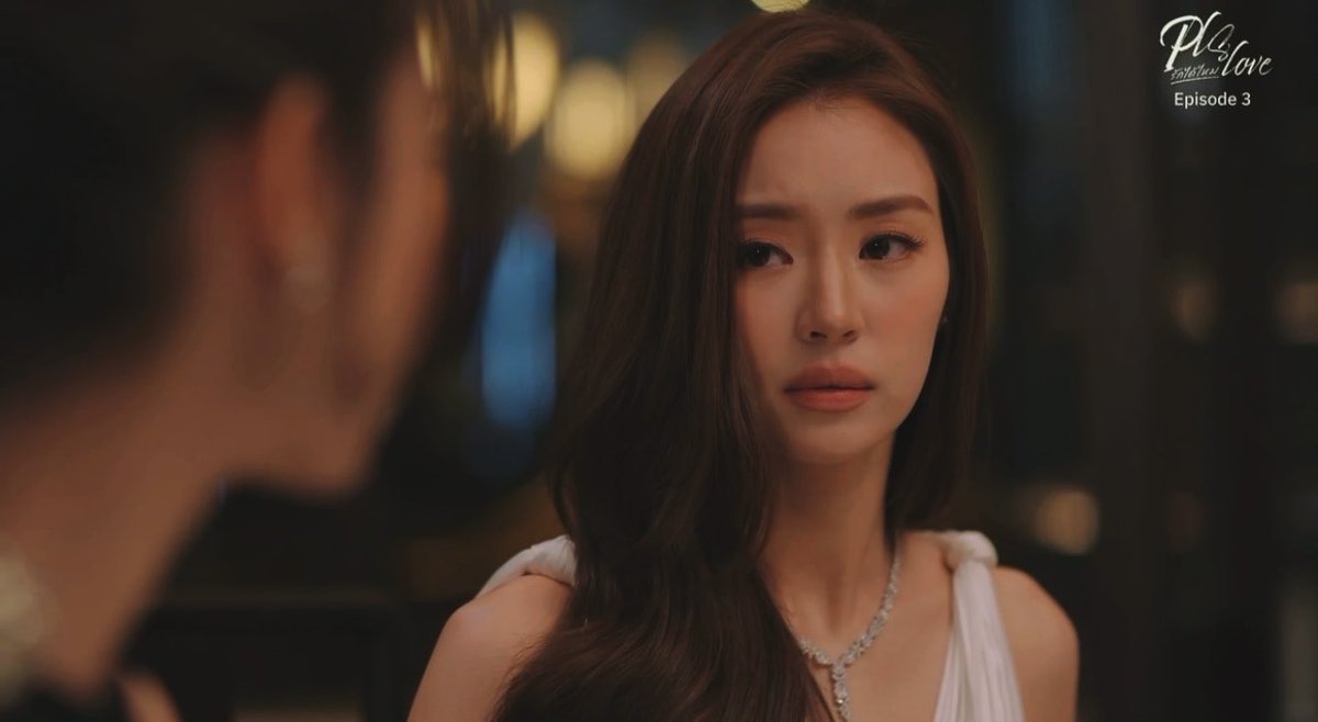 A still from a show titled 'Play for Love Episode 3' featuring a woman with long dark hair in a white dress looking intently at another person.