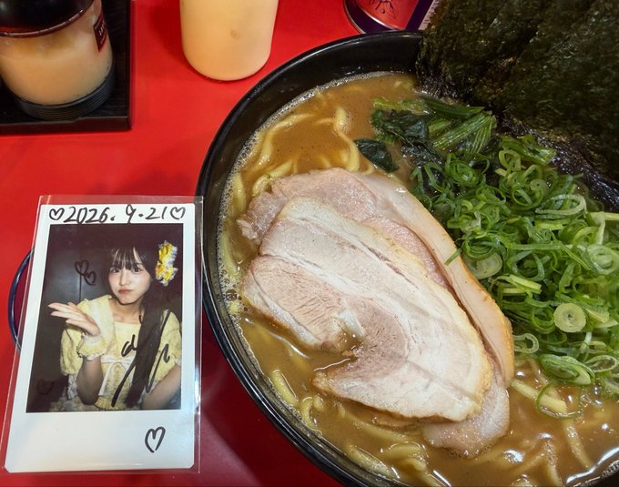 A bowl of ramen topped with chashu pork, scallions, and nori sits next to a polaroid photo dated 2026.4.21, with eggs visible in the background.