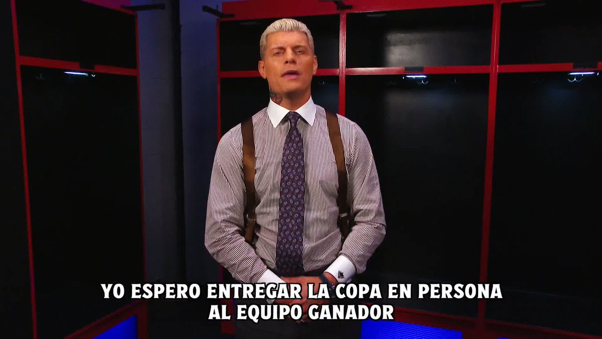 Cody Rhodes stands in a dark locker room setting, wearing a striped shirt, patterned tie, and suspenders, delivering a message in Spanish about personally delivering the trophy to the winning team. The Spanish subtitles read "YO ESPERO ENTREGAR LA COPA EN PERSONA AL EQUIPO GANADOR," which translates to "I hope to personally deliver the cup to the winning team," connecting to his promotional role for the Dusty Rhodes Tag Team Classic as mentioned in the accompanying post.