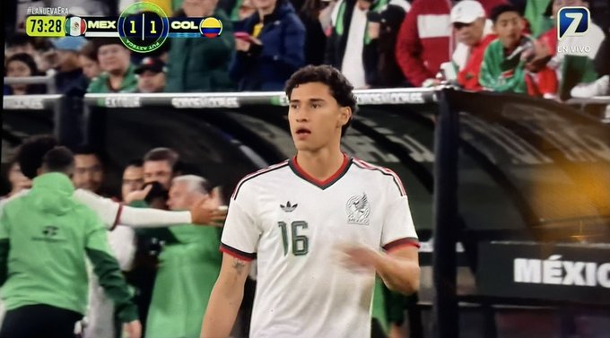 A broadcast screenshot of a Mexico vs. Colombia match shows a Mexican player wearing jersey number 16, with the score tied 1-1 at 73:28.