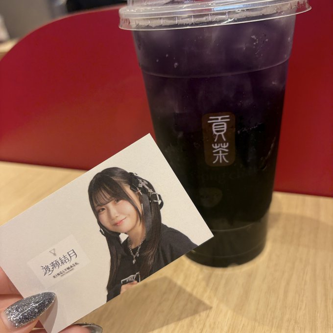 A bubble tea drink from '貢茶' (Gong Cha) next to a polaroid photo of a young woman, held by someone with glittery nail polish.