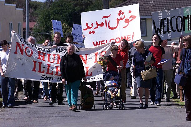 25YearsAgoLive's tweet photo. The first plane-load of Afghan refugees arrives in Auckland, New Zealand.

They are greeted by supporters waving signs bearing slogans such as “No Human is Illegal” and “Hands off Afghanistan.” https://t.co/Bce4KXdDCK