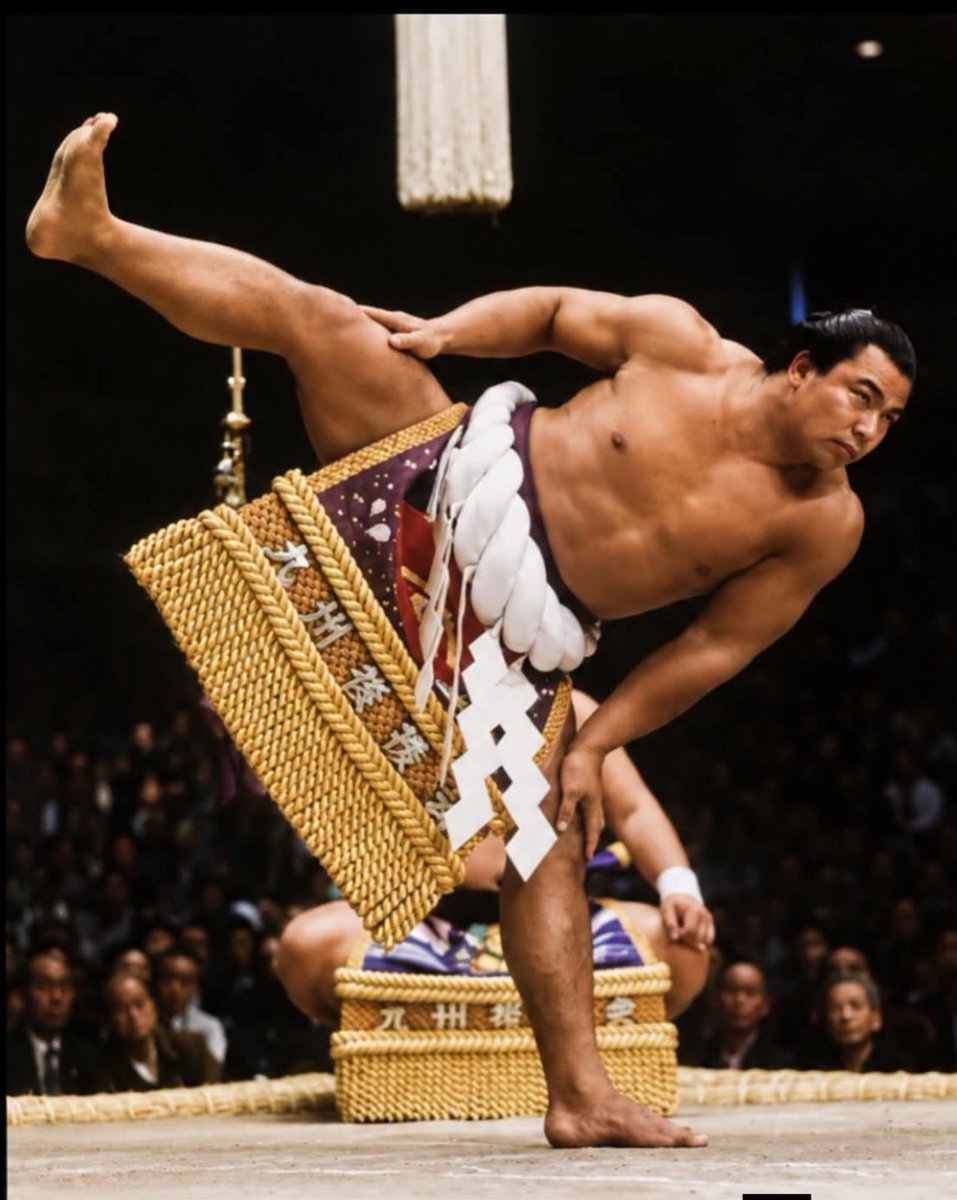 archeohistories's tweet photo. The 58th Yokozuna, Chiyonofuji Mitsugu, performing the dohyō-iri (ceremonial ring entrance) in 1983. Nicknamed "The Wolf," he is widely regarded as one of the greatest sumo wrestlers in modern history due to his exceptional strength, technical skill, and remarkably lean, muscular build... 

A yokozuna is the highest rank in professional sumo, reserved for wrestlers who combine outstanding results with exceptional dignity. Unlike lower-ranked wrestlers, a yokozuna cannot be demoted; when he can no longer meet the rank’s demands, retirement is expected.

Chiyonofuji was promoted to the rank in 1981, becoming sumo’s 58th yokozuna. Known as “The Wolf,” he was more muscular and athletic-looking than many of his larger opponents. Rather than relying on bulk alone, he used speed, balance and precise technique to throw or force them from the ring. His compact build made every victory over a heavier rival part of his signature.

He remained yokozuna for a decade and won 31 top-division championships, establishing himself as one of the sport’s defining champions. His strength and longevity made him a household name in Japan, while his dramatic style helped bring new attention to sumo. He retired in 1991, but his image—muscular, focused and wearing the braided rope of a yokozuna—remains one of the most recognizable in the sport’s modern history. 

In 1989, Chiyonofuji became the first sumo wrestler to receive Japan’s People’s Honour Award, after reaching 965 career wins.

#archaeohistories