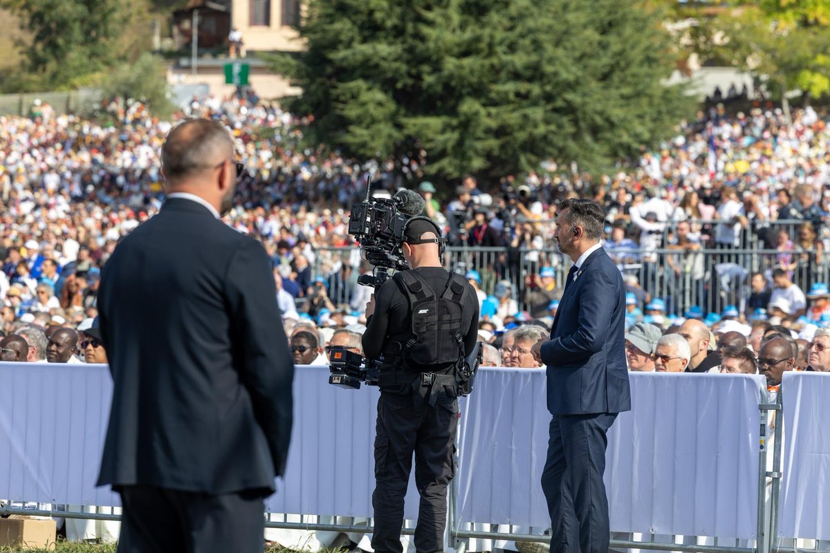 PoliceNationale's tweet photo. À Lourdes, la messe de Léon XIV se déroule actuellement devant le sanctuaire. 150 000 personnes sont présentes. Les policiers en civil du service de la protection (SDLP) sont au plus des autorités ecclésiastiques pour assurer leur sécurité. Ils veillent. https://t.co/o9OWTjoyPU