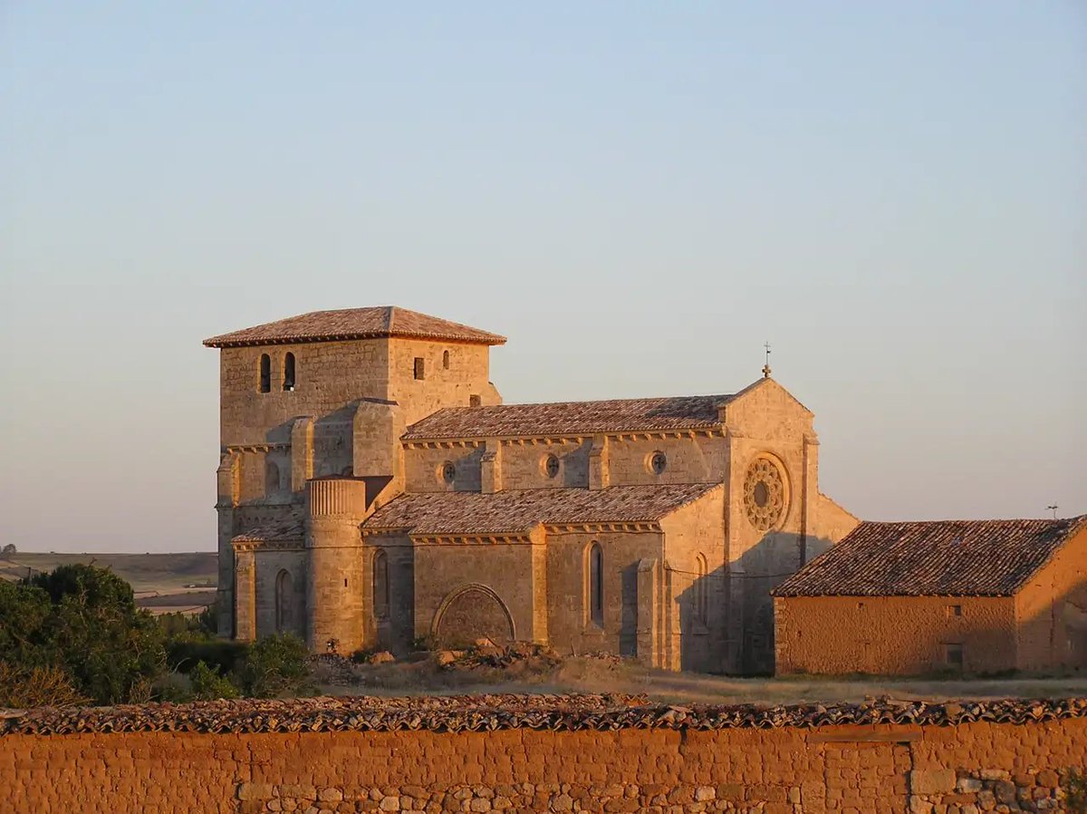 ElCampoAmarillo's tweet photo. En Villamorón, un pueblecito del oeste de Burgos, vive una sola persona según el padrón. Y en mitad de sus casas hay una iglesia tan grande que en la comarca la llaman la Catedral del Páramo. Se ve desde muy lejos, asomando entre los trigales del llano de Villadiego, con una torre tan maciza que parece la de un castillo. De hecho algo de eso tiene, porque en el siglo XIV la subieron y la reforzaron para poder defenderse desde ella.

Es la iglesia de Santiago Apóstol, del siglo XIII, de cuando el gótico empezaba a llegar a Castilla. La hicieron en piedra caliza, con tres naves y unos pilares rodeados de columnas que se parecen mucho a los de la catedral de Burgos, y en la fachada principal le pusieron un rosetón enorme. Fernando Chueca Goitia, que sabía de esto como pocos, la consideraba una de las tres mejores iglesias góticas de la Castilla de su tiempo, junto con la de Villalcázar de Sirga y la de Villamuriel de Cerrato.

Y hay un dato que a mí me dejó bastante sorprendido cuando lo leí. Después de que Fernando III conquistara Córdoba en 1236, allí se levantaron muchas parroquias nuevas, las que hoy se conocen como iglesias fernandinas, y para hacerlas se tomó como modelo precisamente esta de Villamorón. Media Córdoba medieval tiene algo de este pueblo burgalés que casi nadie sabría señalar en un mapa.

Si pasas por la zona, merece la pena desviarse. En los años setenta, cuando el pueblo se fue quedando vacío, la iglesia estuvo a punto de hundirse, y en 1970 se llevaron a Burgos todo lo que tenía dentro, incluido un Cristo gótico de tamaño natural que ahora está en el Museo del Retablo. Si sigue en pie es gracias a la Asociación de Amigos de Villamorón, que se empeñó en restaurarla, y el trabajo les salió tan bien que en 2024 quedaron finalistas en unos premios europeos de patrimonio religioso. En verano suelen abrirla algunos fines de semana.