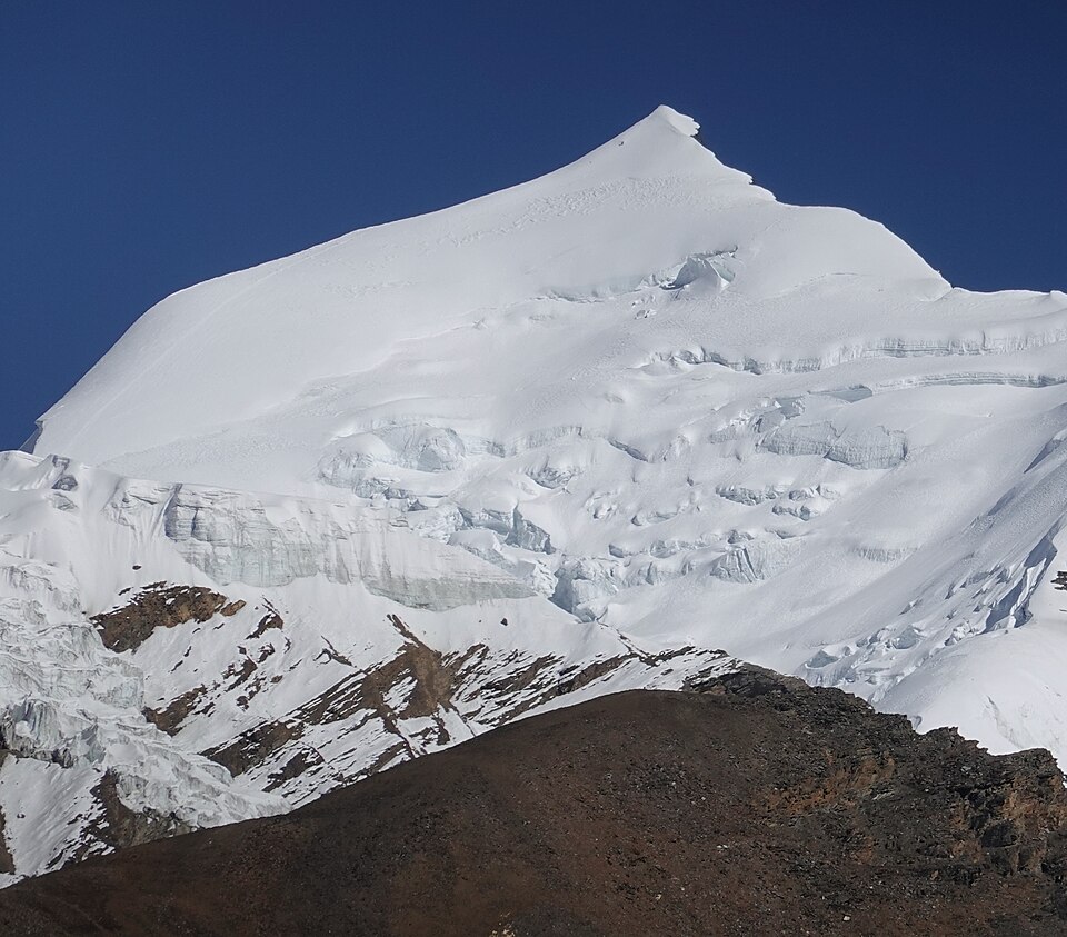 EscribaDiurno's tweet photo. Avalancha en Himlung Himal (7.126 m), Manang, Nepal. Esta mañana una avalancha cubrió el campamento base. Hay 10 personas desaparecidas: 8 de Himalayan Holidays Nepal y 2 de cocina de Imagine Nepal (equipo de Mingma G).
Eran personal de apoyo que permaneció o regresó al campamento pese a las alertas meteorológicas. El resto de equipos ya había bajado. El mal tiempo (nieve y lluvia intensa) impide el vuelo de helicópteros. Un equipo de 8 guías IFMGA espera en Katmandú para el rescate.
Autoridades y organizadores confirman el hecho. Todavía no hay identidades públicas ni confirmación de víctimas. El clima sigue complicando las operaciones.
Foto de archivo del campamento base (2019): Hermann Haertig / Wikimedia Commons / CC BY-SA 4.0
#HimlungHimal #Avalancha #Nepal #Manang