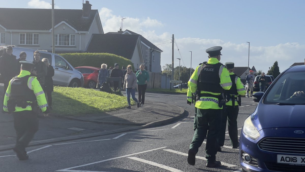 Kscott_94's tweet photo. Update: Police in high vis made an approach to protesters here on the Garvaghy Road.

They were looking to speak to anyone in the crowd with influence.

Paul Maskey told them that no one wanted to engage.

Officers have now retreated behind a TSG unit @BelTel https://t.co/br1EuCbmAl