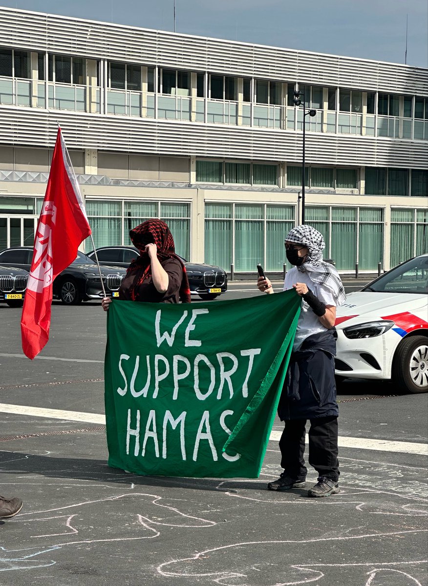 SherminAmiri's tweet photo. Je komt aan bij het D66-congres en pal voor de ingang staan Hamas-lovers met ‘We support Hamas’. En de politie staat erbij en kijkt toe. https://t.co/YrzpPqgxfX